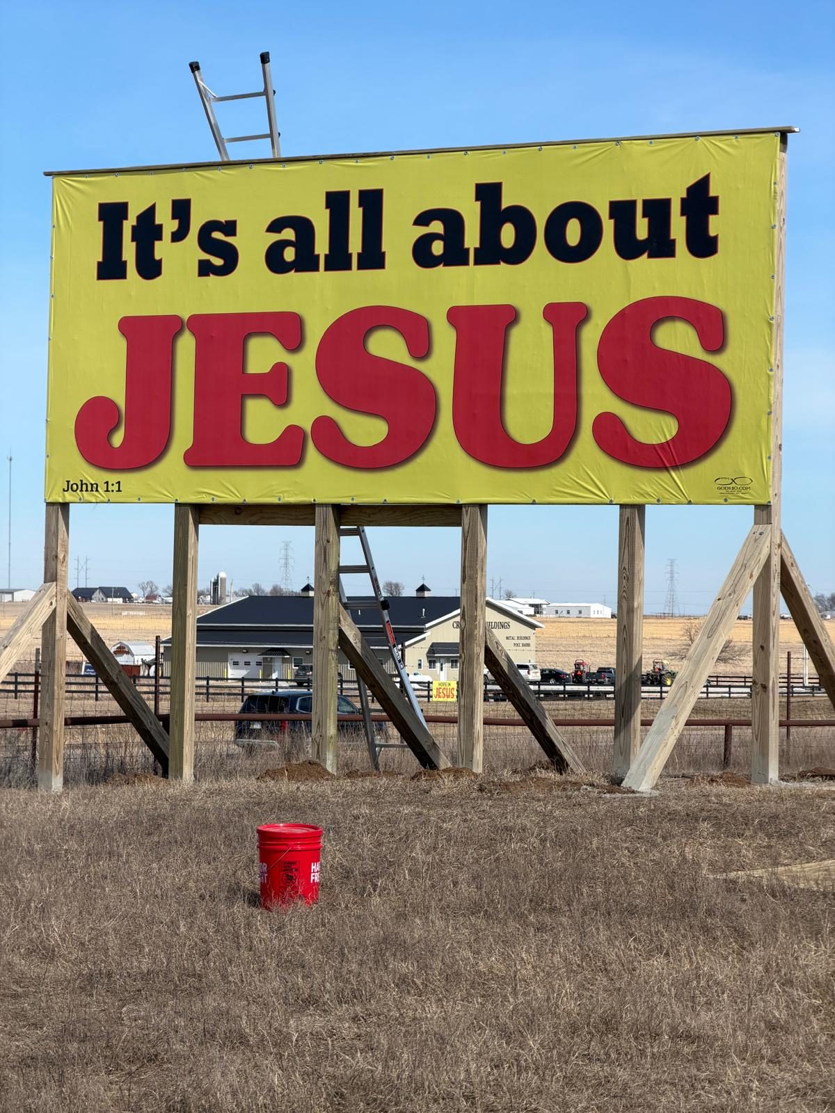 An It's all about JESUS billboard, John 1:1, in a rural field